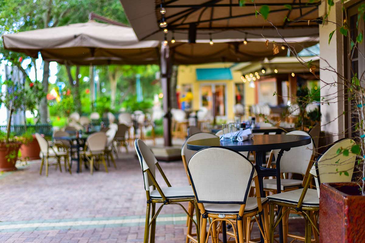 Best Outdoor Dining Restaurants Lakeview View of outdoor restaurant dining with tables and chairs on red brick sidewalk.
