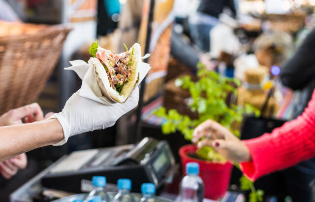 Street Festival Worker Handing Taco to Attendee