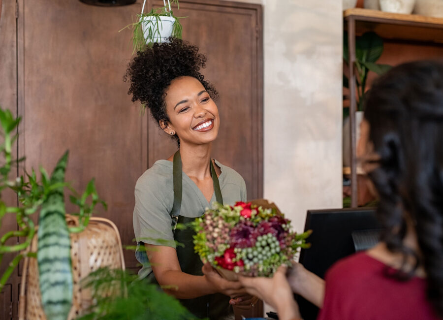 Woman giving flowers to another woman