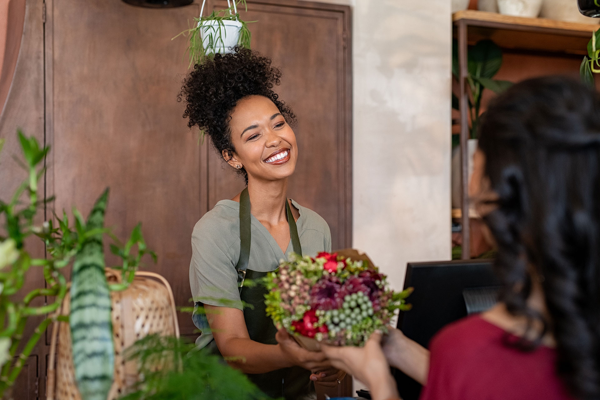 A florist handing a customer a bouquet of flowers outside a shop in Lakeview, Chicago.
