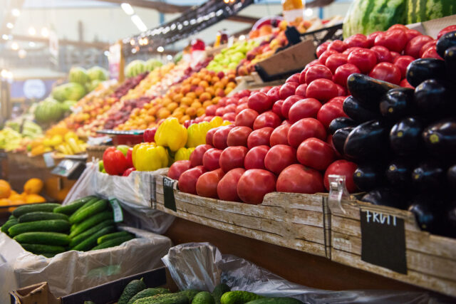 a row of fruit and vegetables in a grocery store