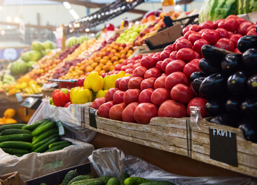 a row of fruit and vegetables in a grocery store